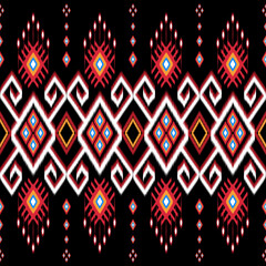 Bold ethnic Ikat pattern featuring red, white, and gold geometric shapes with diamond and heart motifs on a black background. Ideal for fabric design, home decor, and fashion with a tribal-inspired 