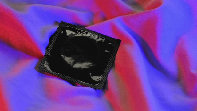 Condom on the bed. Safe sex and contraception. Intimate atmosphere