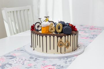 Beautiful birthday cake. The cake has a marzipan bike and camera. Marked with the number 60