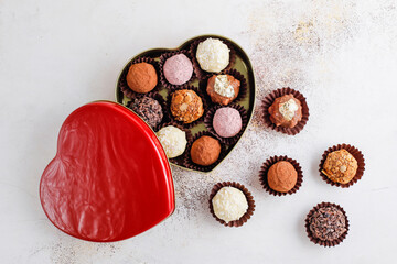Homemade chocolate truffles with dark chocolate ganache covered with pink powder, waffle crumbles, gold flakes, coconut and nuts