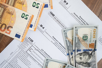 Tax documents and banknotes on a desk. Financial paperwork, tax forms, and currency representing tax time and financial management. 