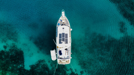 Aerial view from above of a large eco-friendly yacht with solar panels receiving energy during the...