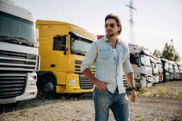 In sunglasses. Truck driver is near the transport outdoors