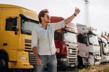 Friendly hand gesture. Truck driver is near the transport outdoors