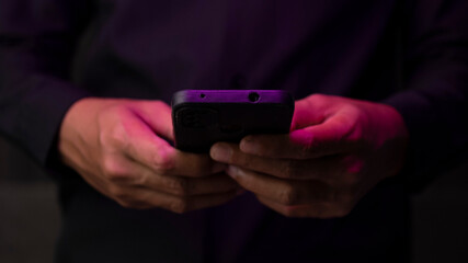 Middle part of businessman using smart phone while standing with black backgriund background.