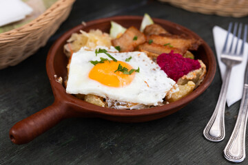 Scrambled eggs with fried bacon and potatoes served on plate