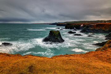 rocky shore with a surf with foam on the water