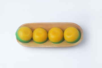 Photo seen from above of a round, yellow-green layered cake in a wooden bowl