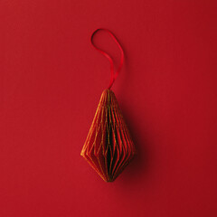 Bright Red Paper Christmas Ornaments, winter seasonal holiday decorations on red background with copy space, Happy holiday card minimal style, vivid dark color. Top view handcraft Christmas bauble