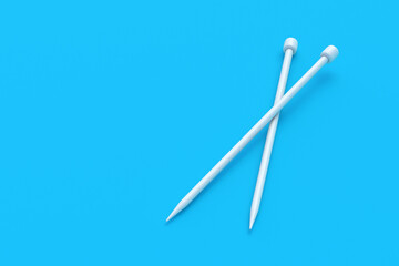 Two knitting needles on blue background. Sticks for knit. Needlework tool. Handicraft equipment. Copy space. 3d render