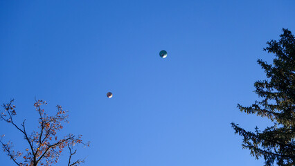 Two hot air balloons from above in a clear blue sky