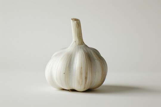 A close-up shot of a garlic bulb on a white surface