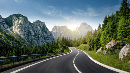 Fototapeta premium Winding mountain road through rocky terrain and green forest