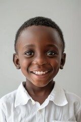 Naklejka premium A happy young boy smiling and wearing a white shirt, suitable for family or children's photoshoots