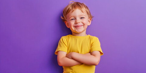 Joyful toddler boy with a bright smile posing against a vibrant purple background