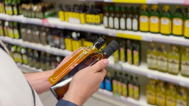 choosing olive oil, sauce, vinegar at the grocery store
