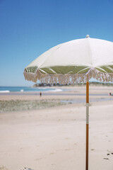 A green beach umbrella in the sand on an Australian beach