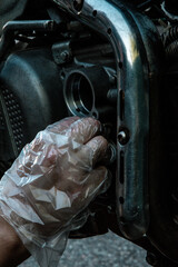 hand replaces the oil filter on the motorcycle and looks at all the details