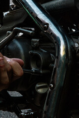 hand replaces the oil filter on the motorcycle and looks at all the details