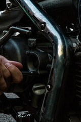 hand replaces the oil filter on the motorcycle and looks at all the details