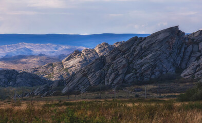 Beautiful rocky and layered mountains in Eastern Kazakhstan near the Sibinsk lakes under a stunning sunset sky