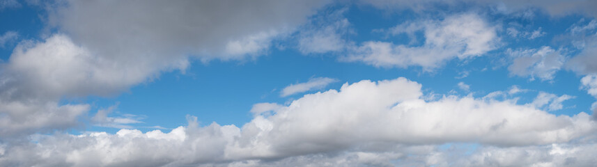 blue sky with several cumullus clouds, panorama format