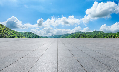 Empty square floor and green forest with mountain natural landscape under blue sky. Panoramic view.