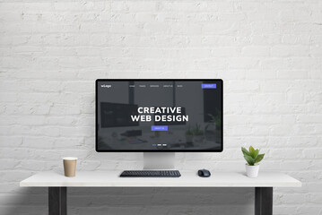 Clean creative web design page from code studio displayed on a computer at a tidy office desk with...