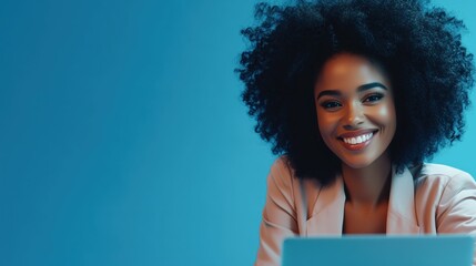 Fototapeta premium Portrait of a Smiling Woman with Afro Hair Sitting Against a Vibrant Blue Background