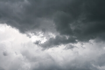 Dark dramatic rain clouds contrasting with white clouds in the background.