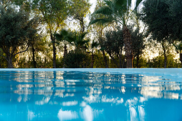 Stunning landscape, swimming pool blue sky with clouds. Oriental resort hotel in Marrakech. Fantastic relax and peaceful vibes, chairs, loungers under umbrella and palm leaves. Luxury travel vacation