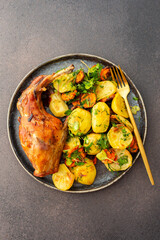 A hearty delicious dinner, baked rabbit with potatoes and carrots, a set table with food