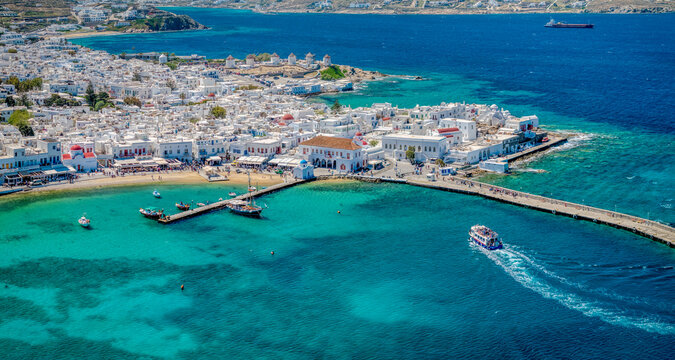  Mykonos Town hall aerial view wide with seabus coming to port and the windmills in the back on a sunny summer day.