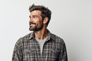 Obraz premium Portrait of a tender man in his 30s dressed in a relaxed flannel shirt in white background