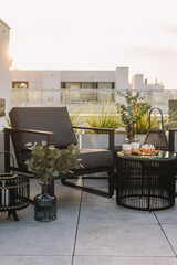 Patio furniture set on rooftop terrace with armchair, table and potted plants