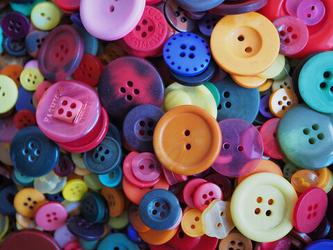 Viele bunte Plastikkn&ouml;pfe in verschiedenen Gr&ouml;&szlig;en liegen auf einem Haufen