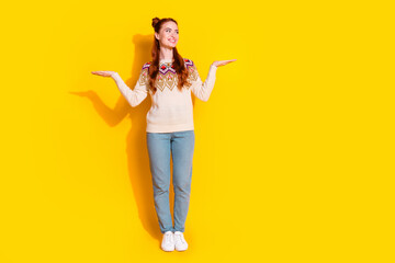 Photo portrait of attractive young woman compare look empty space dressed stylish knitted warm outfit isolated on yellow color background