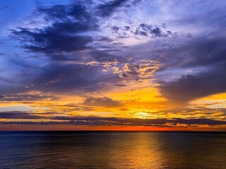 Majestic sunset in ominous heaven over dark sea at night.