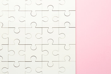 White puzzle on pink background, top view