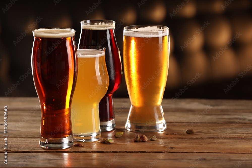 Canvas Prints Glasses with different types of beer and pistachio nuts on wooden table indoors