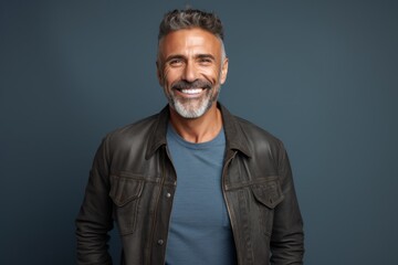 Obraz premium Portrait of a happy man in his 50s sporting a rugged denim jacket in front of modern minimalist interior