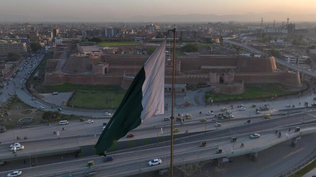 Big Flag of Pakistan in Peshawar in slow motion at sunset time, evening. Bala Hisar Fort Peshawar Pakistan, Drone Aerial