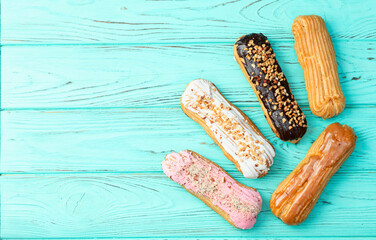 Assorted eclairs on a pastel top view Traditional French dessert