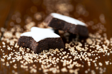 Christmas cookies (cinnamon stars) and brown sugar on dark background. Close up.	