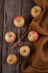 Cinnamon sticks, apples towel on wooden table