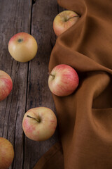 Fresh small apples and towel on wooden table