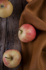Fresh small apples and towel on wooden table