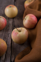 Fresh small apples and towel on wooden table