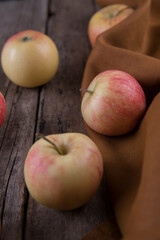 Fresh small apples and towel on wooden table