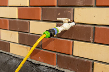 Outdoor water faucet. Connected garden hose. Connecting coupling